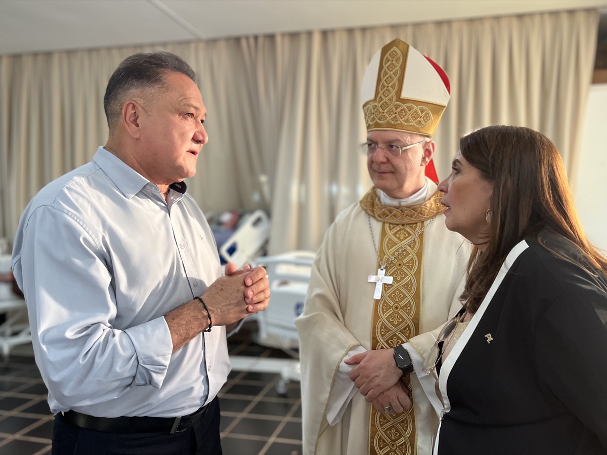 João Cardoso e Bia Kicis conversando com um bispo em ambiente hospitalar